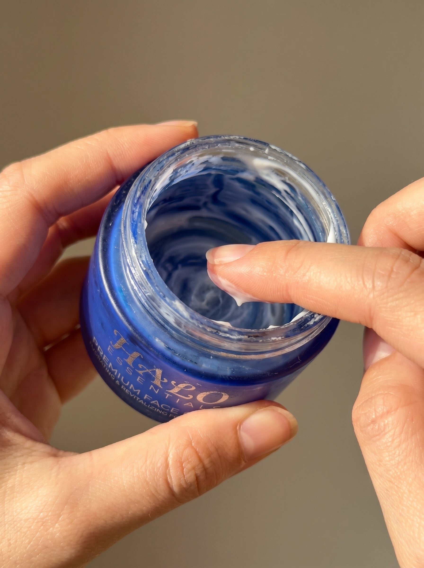 Scooping the last of a well-used face cream jar